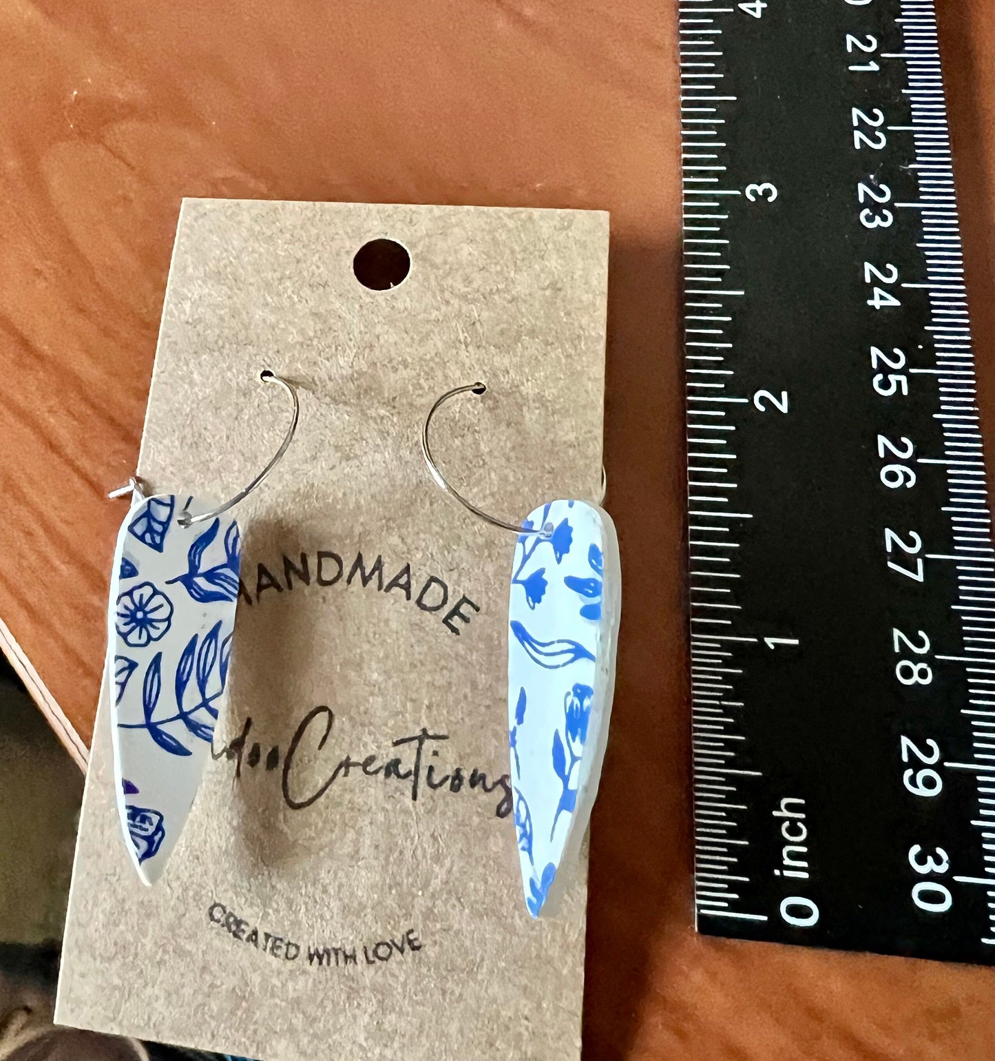 Blue & white floral dangling painted clay earrings handmade wire hoop closure lightweight The Dagger