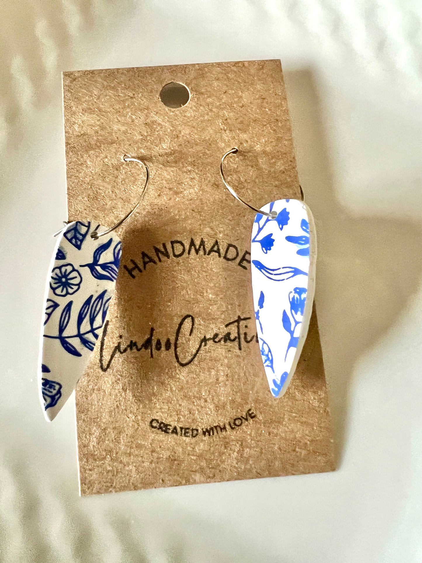 Blue & white floral dangling painted clay earrings handmade wire hoop closure lightweight The Dagger
